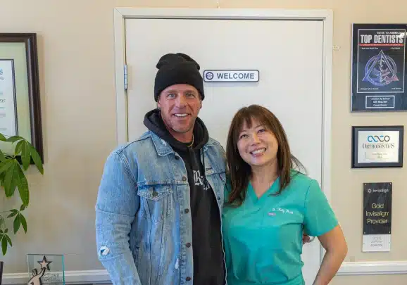 Two people posing together inside Kelly Smile Dentistry office in Victorville